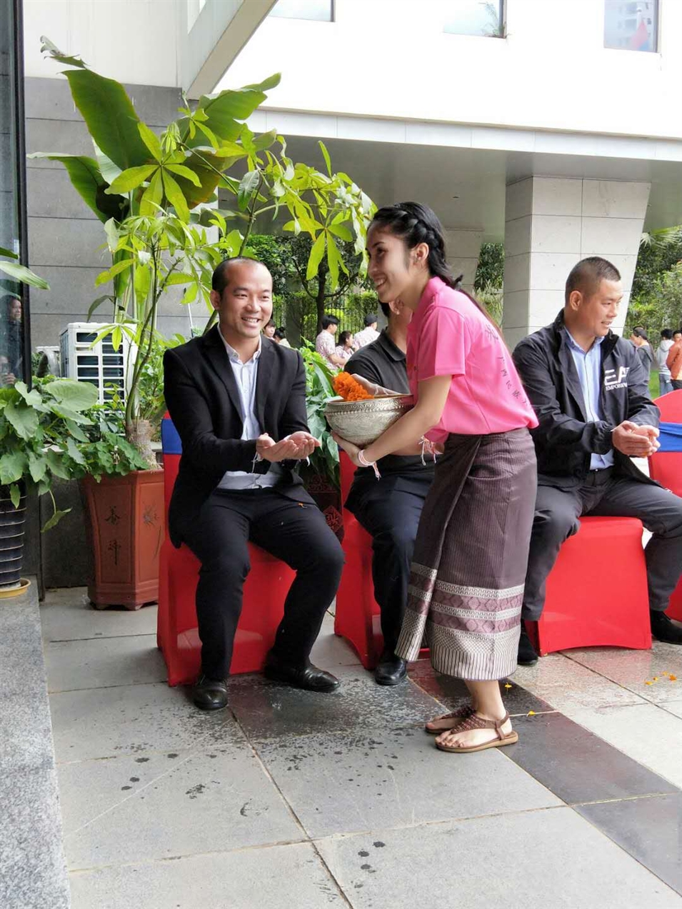 老撾駐廣西留學(xué)生代表將浸有花瓣的香水灑客人的手上，表示對嘉賓的美好祝福（圖一）